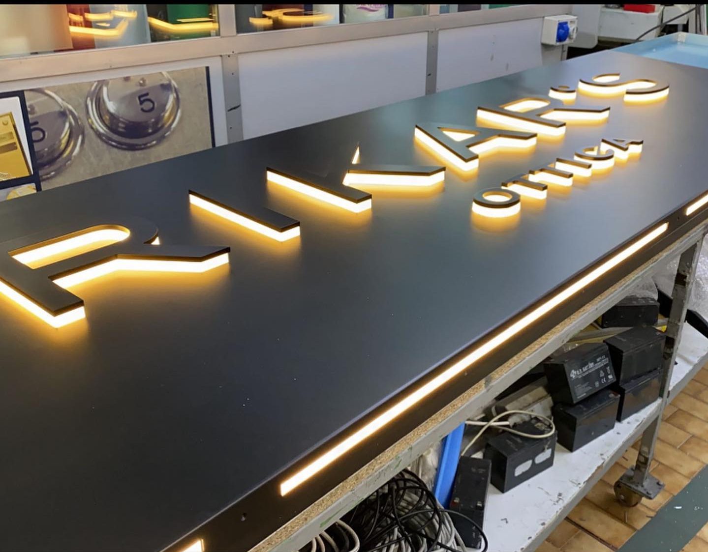 Insegna luminosa in alluminio 20/10 verniciatura a polvere in nero opaco con lettere massello retroilluminate a luce indiretta